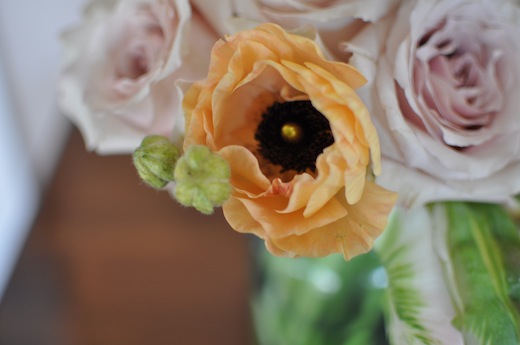 ranunculus and amnesia roses in blue ball jar